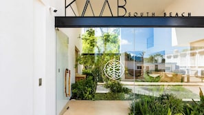 Ein Hotel Eingang mit Glasfassade, einem Logo und der Aufschrift 'KAAB SOUTH BEACH'.