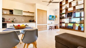 Una cucina moderna con zona pranzo, televisione e libreria con libri e oggetti decorativi.