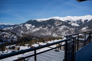 A mountain landscape with snow-covered peaks and a residential area below. - Steamboat by Alpine Resorts (Courchevel)