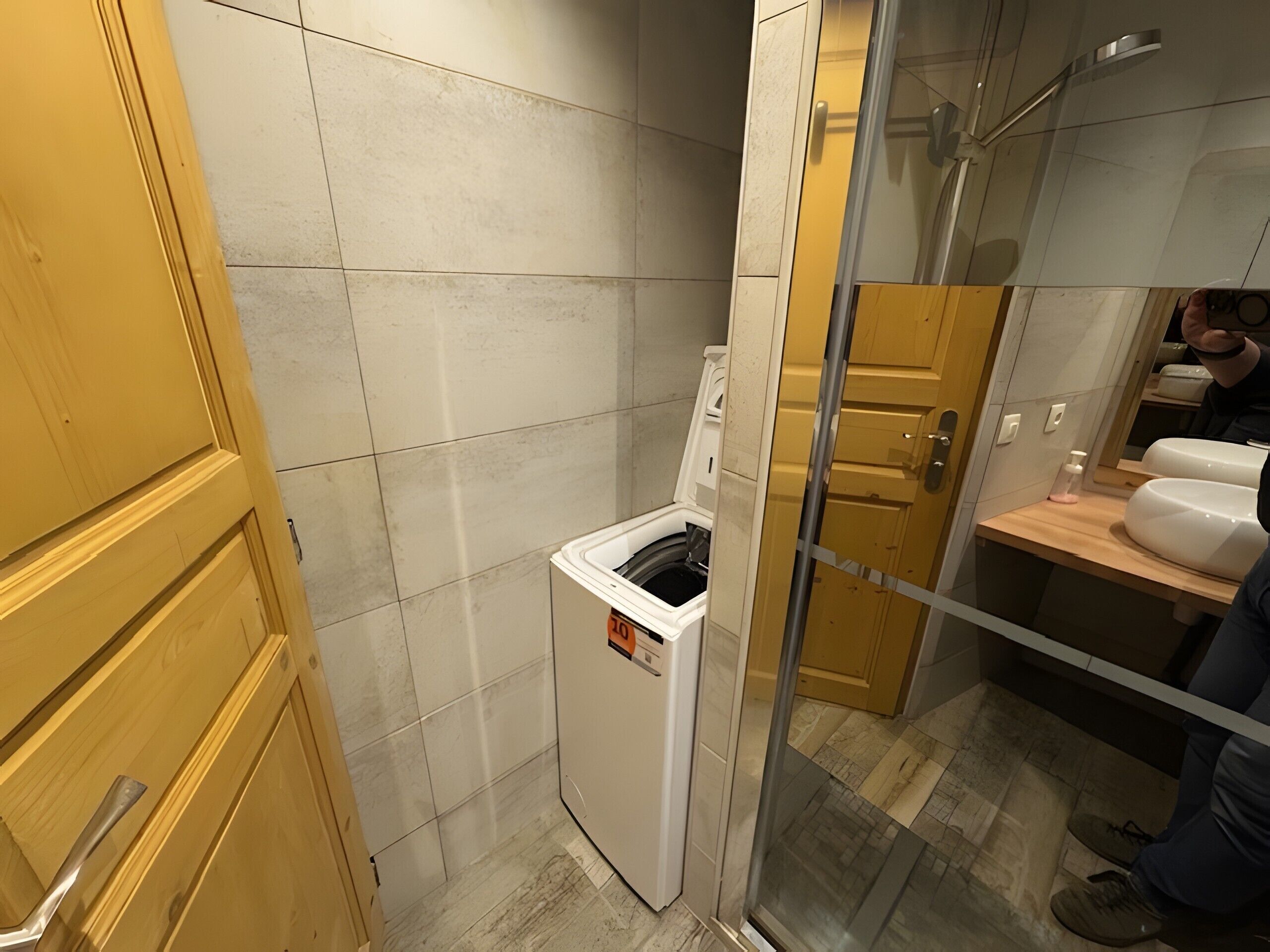 Une petite salle de bain comprenant des toilettes, un petit lavabo et une cabine de douche en verre.