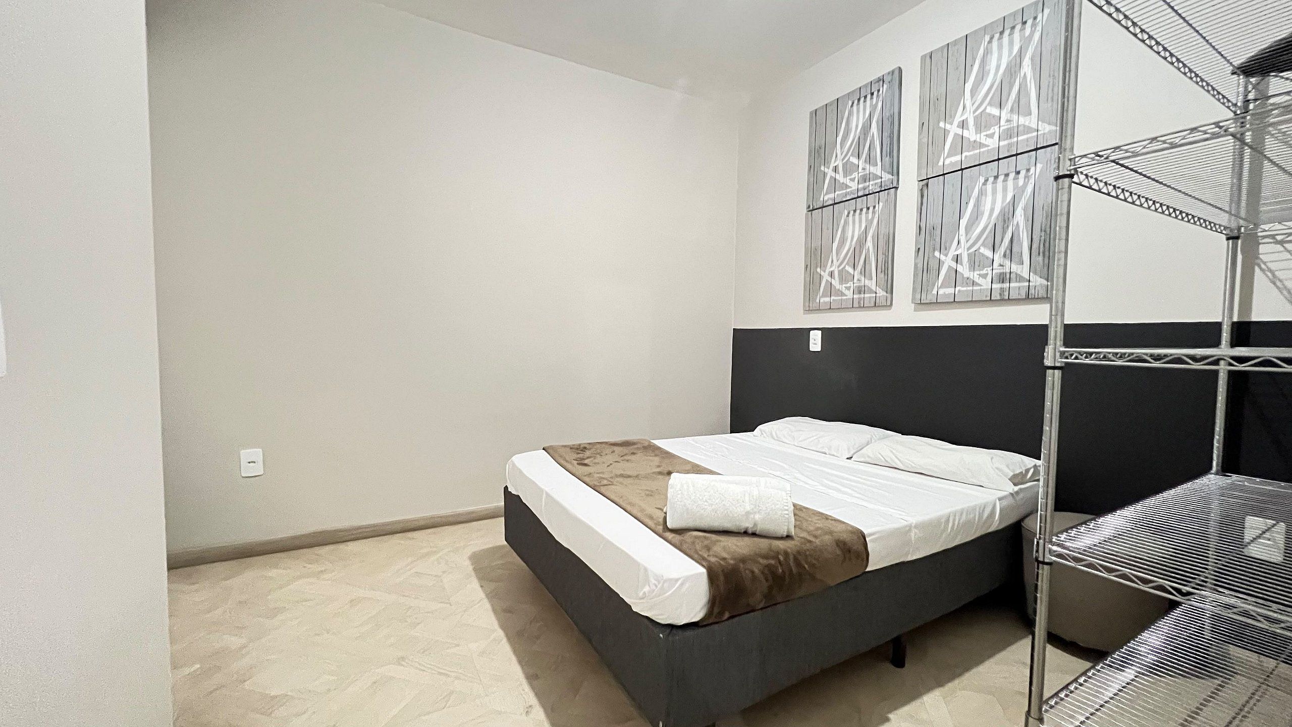 Un dormitorio con cama, cabecera y estructura de literas.