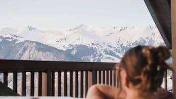 Una persona en un jacuzzi con vista a la montaña.