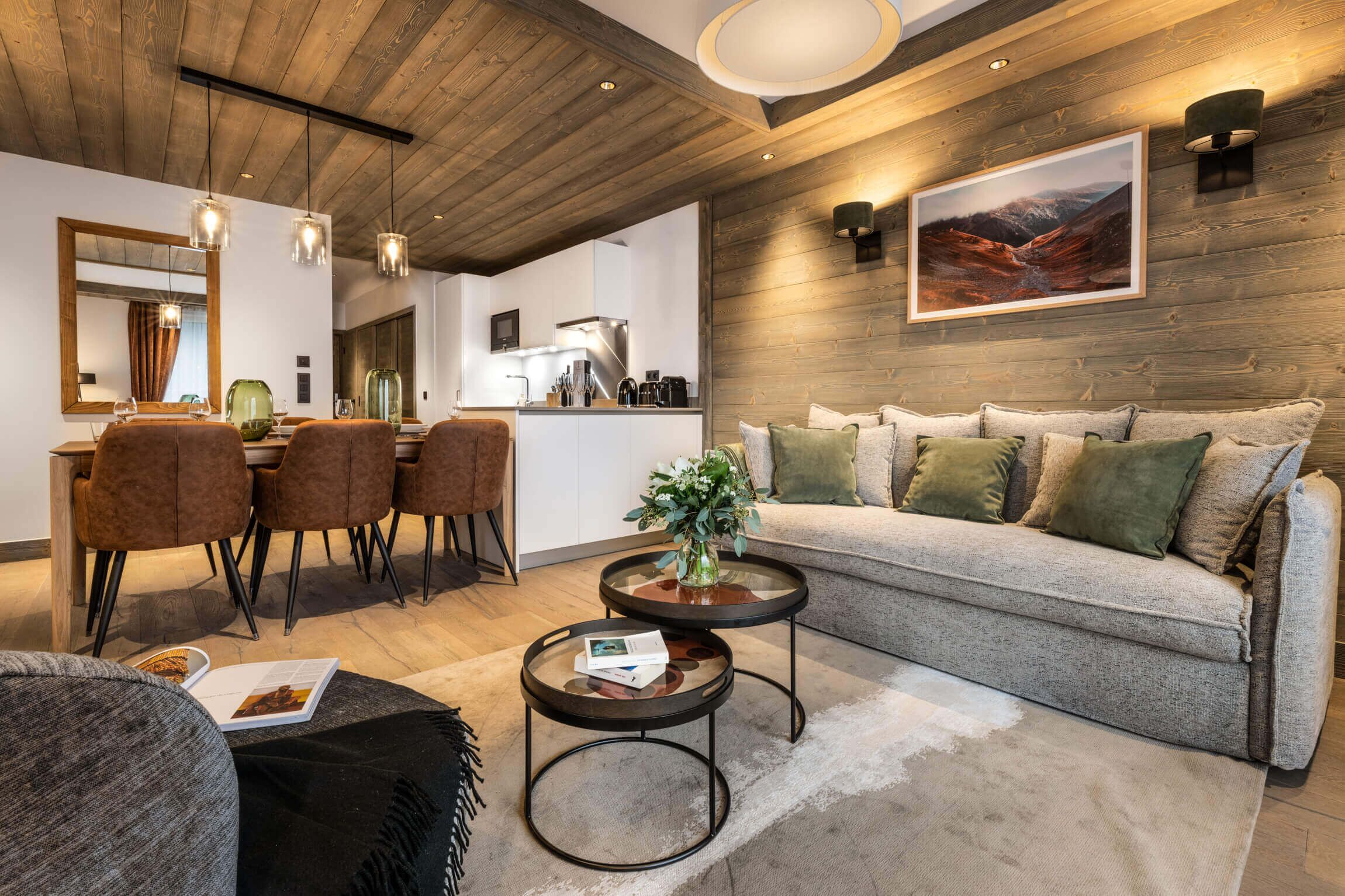 Una sala de estar moderna con techo de madera, un sofá, un comedor y una cocina.