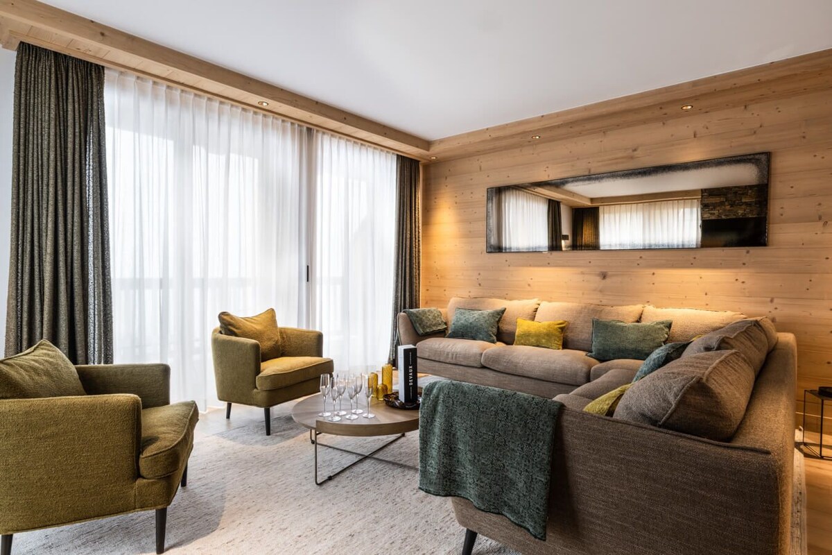 A modern living room with a sofa, armchairs, and a coffee table.