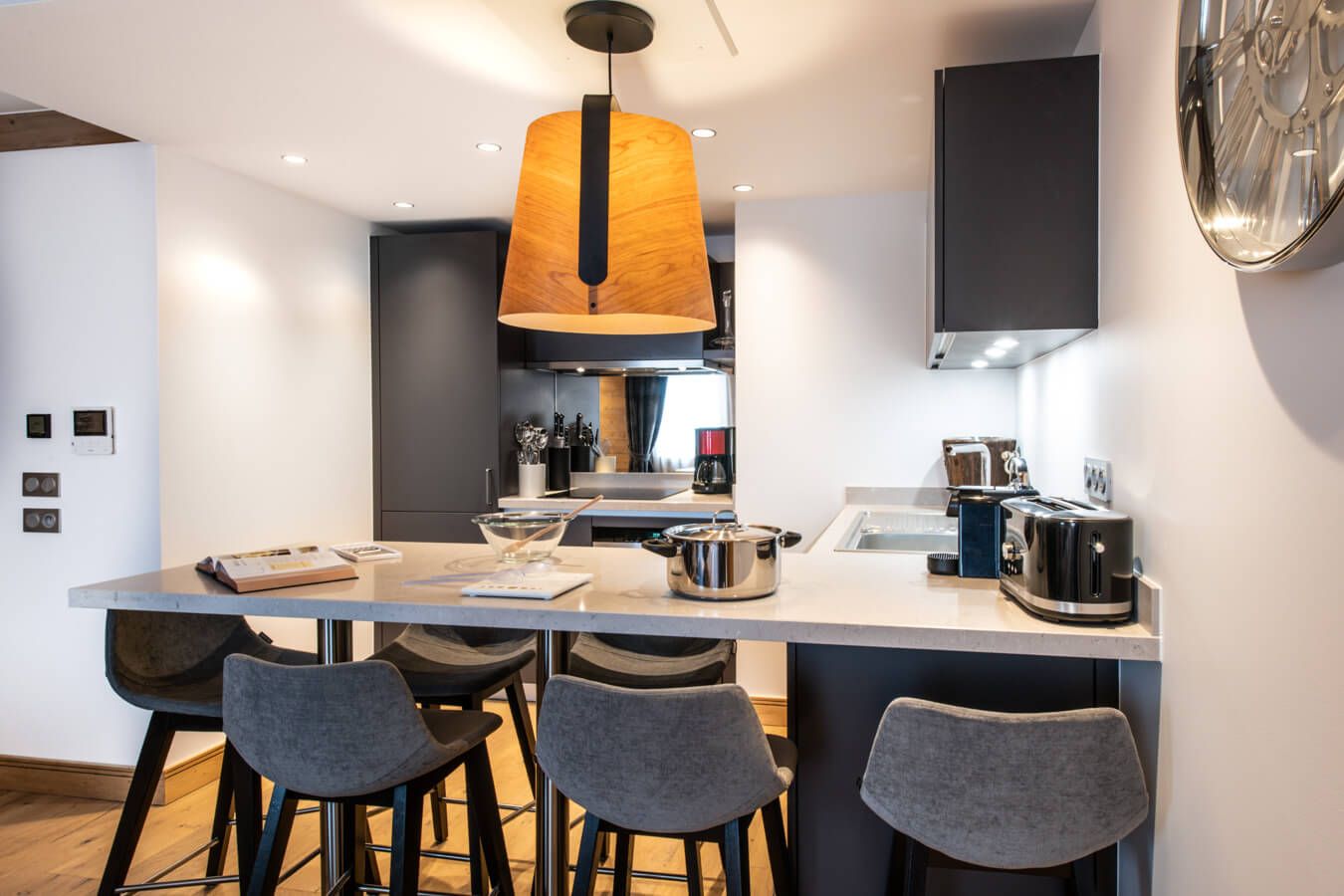 Una cocina moderna con una isla central, taburetes de bar y electrodomésticos contemporáneos.
