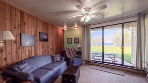 A living room with a sofa, armchairs, a coffee table, a ceiling fan, and a large sliding glass door leading to an outdoor area. - `The Alice` in Ideal Beach Resort (Garden City)