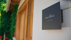 A sign for 'Malbec Room' on a building's exterior wall. - Casa de Coria (Chacras de Coria)