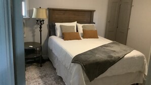 A bedroom with a bed, bedside table, lamp, and wardrobe. - Sweetdillatpicklesgap (Conway)