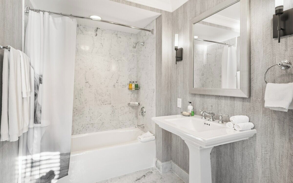 A modern bathroom with a bathtub, a sink, and a shower area.