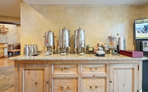 Eine Küche mit Edelstahl-Kaffeemaschinen, einer Kaffeekanne und einem Kühlschrank.