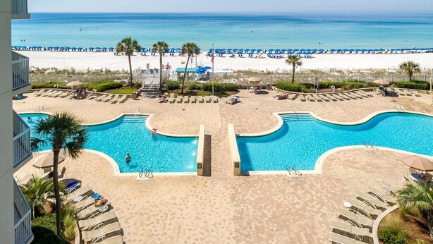 A pool area with two pools, a beach, and a view of the ocean. - Silver Beach Towers 102w- Southern Heirs (Destin)