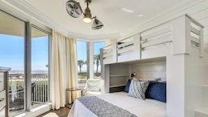 A bedroom with a large bed, a seating area, and a balcony with a view. - Silver Beach Towers 102w- Southern Heirs (Destin)