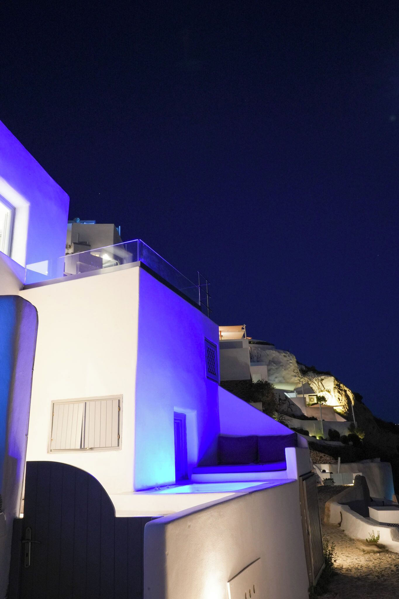 A modern building with a flat roof, a balcony, and a door.