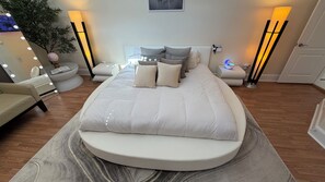 A modern bedroom with a large bed, bedside tables, a chair, and a floor lamp.
