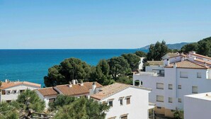 Una zona residencial costera con edificios blancos, tejados de tejas rojas y vistas al mar.