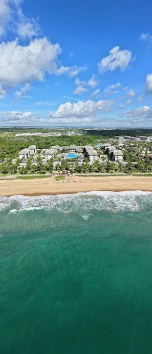 Ein Küstenresort mit Strandhäusern, einem Schwimmbad und Meerblick.
