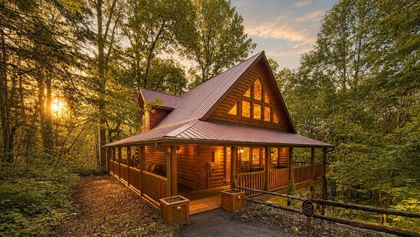 Eine Holzhütte mit Veranda, umgeben von Bäumen.