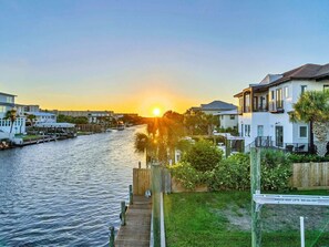 A waterfront property with a dock, a boat lift sign, and residential buildings. - Yellow Fin Place (Destin)