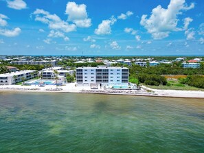 A coastal hotel with multiple buildings, a pool, and a beach view. - P48 - 2 Bedroom, 2 Bath Beach front condo with pool (Marathon)
