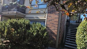 A two-story building with a balcony, a brick wall, and a gate. - Beautiful stylish vacation, Dream home (Kent)