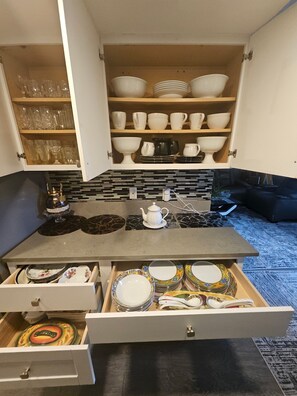 A kitchen with a countertop, a drawer with plates, and shelves with bowls and glasses. - Beautiful stylish vacation, Dream home (Kent)