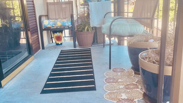 A welcome mat with 'WELCOME TO OUR HOME' text, a chair with a cushion, a potted plant, and a metal chair with a cushion. - Beautiful stylish vacation, Dream home (Kent)