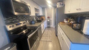 A modern kitchen with stainless steel appliances, a microwave, a toaster, and a coffee maker. - Beautiful stylish vacation, Dream home (Kent)