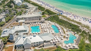 Un complejo turístico con varias piscinas, acceso a la playa y una variedad de edificios.