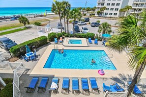 A swimming pool with lounge chairs, a smaller pool, and a view of the ocean. - Summerspell 305 (Miramar Beach)