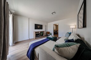 Ein modernes Hotelzimmer mit Bett, Fernseher, einer kleinen Ablage und Blick auf den Speisesaal.