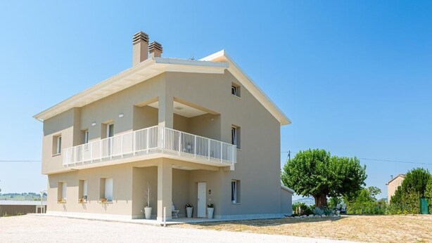 A two-story building with a balcony, a chimney, and a clear sky. - Dolce Conero Guest House (Camerano)