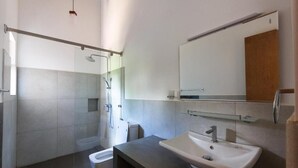 Une salle de bain moderne équipée d’une douche, de toilettes et d’un lavabo.