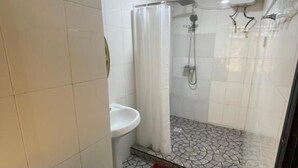 A bathroom with a shower, toilet, and sink.