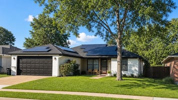 Casa residencial con garaje, paneles solares, césped cuidado y el número 737.