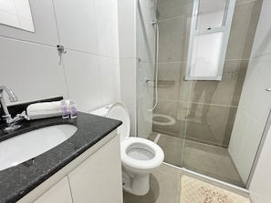 A bathroom with a sink, toilet, and shower.