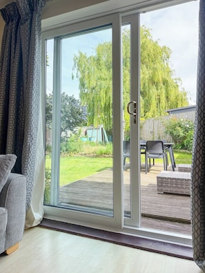 A room with a sliding glass door leading to an outdoor patio area. - NEW Family Home in Whitstable | Pets Welcome (Whitstable)