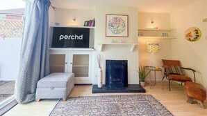 A living room with a fireplace, a television, and a sofa. - NEW Family Home in Whitstable | Pets Welcome (Whitstable)