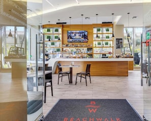 Eine moderne Bar mit Fernseher, Holztresen und Sitzgelegenheiten.