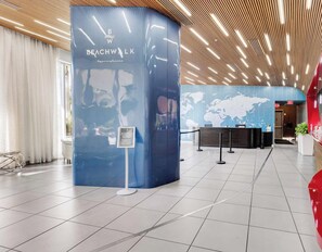 A reception area with a blue pillar displaying the name 'Beachwalk' and a world map on the wall. - Chic Studio w/ Bay & Intracoastal View (Hallandale Beach)