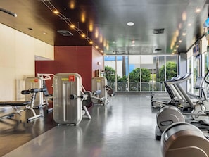 A gym with cardio machines, weight equipment, and large windows offering a view of the outdoors. - Chic Studio w/ Bay & Intracoastal View (Hallandale Beach)