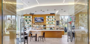 A modern bar area with a TV screen, wooden counter, and seating. - Cozy Studio w/ Intracoastal View & Balcony (Hallandale Beach)