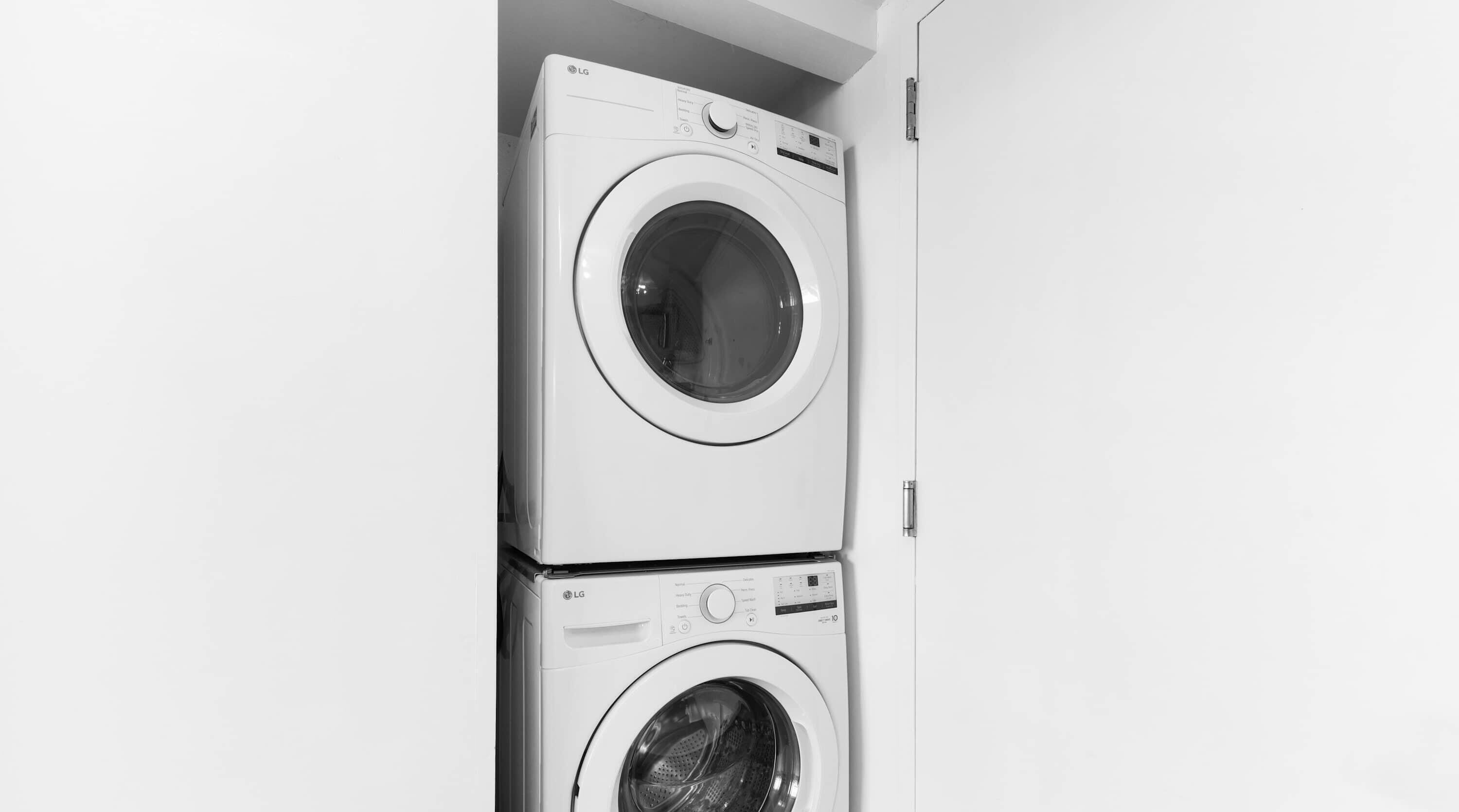 A stacked washer and dryer unit in a laundry room.