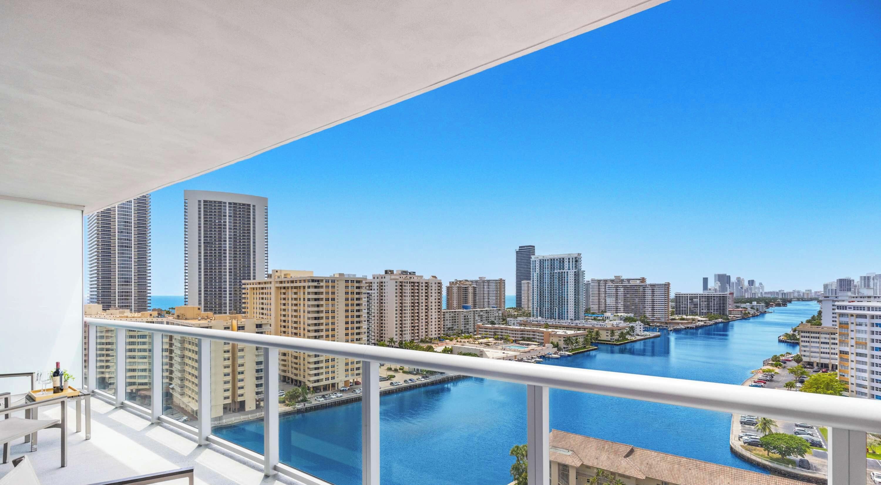 A high-rise building with a view of a river and other buildings.