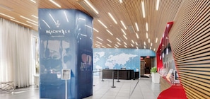 A reception area with a blue pillar displaying the name 'Beachwalk' and a world map on the wall. - New! Chic Studio with Marina & Intracoastal View (Hallandale Beach)
