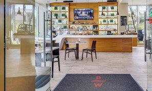 Eine Barbereick mit Fernseher, Regalen voller Flaschen und Sitzgelegenheiten.