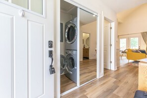 Ein modernes Interieur mit Waschbereich, Holzboden und einem gelben Sofa.