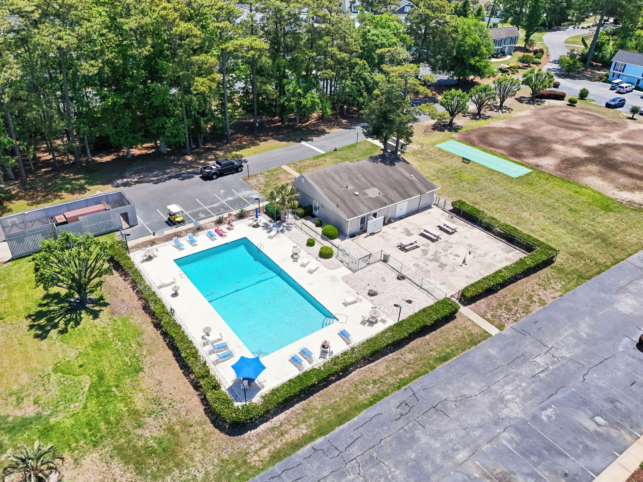 Ein Luftbild eines Wohngebiets mit Schwimmbecken, überdachter Terrasse und Garage.