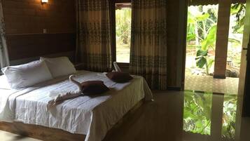 Una camera da letto con un letto, tende e vista sul verde.