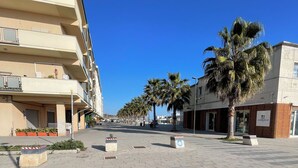 A paved square with palm trees, a building with balconies, and a sign for 'ALDEBARAN'. - "Window to the Sea" Spacious and new sea view apartment (Marina di San Vito)