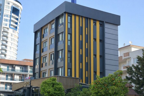 A modern multi-story building with balconies, large windows, and a visible entrance. - Casa Ayris Boutique Hotel (Mersin)